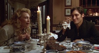 Movie still from “Arizona Dream” (1993), directed by Emir Kusturica – Two people sitting at a dinner table with lit candles; Medium shot, High angle