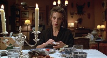 Movie still from “Arizona Dream” (1993), directed by Emir Kusturica – A woman sitting at a dinner table with a lit candle; Medium shot, High angle
