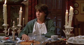 Movie still from “Arizona Dream” (1993), directed by Emir Kusturica – A man sitting at a dinner table with food on the table; Medium shot, High angle