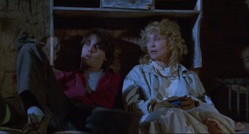Movie still from “Arizona Dream” (1993), directed by Emir Kusturica – A couple of people sitting next to each other on a couch; Medium shot, High angle