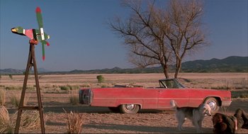 Movie still from “Arizona Dream” (1993), directed by Emir Kusturica – An old car is parked in the middle of a field; Extreme Wide shot, Low angle