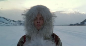 Movie still from “Arizona Dream” (1993), directed by Emir Kusturica – A man in a fur hat standing in the middle of a snow covered field; Medium shot, Low angle