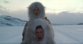 Movie still from “Arizona Dream” (1993), directed by Emir Kusturica – Two people in fur coats are standing in the snow; Medium shot, Low angle