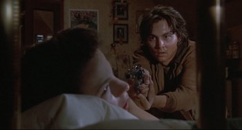 Movie still from “Arizona Dream” (1993), directed by Emir Kusturica – A man holding a gun pointed at a woman; Close Up shot, Over the shoulder angle