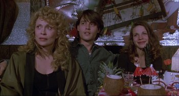 Movie still from “Arizona Dream” (1993), directed by Emir Kusturica – A group of people sitting at a table with food; Medium shot, High angle