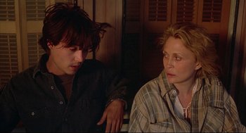 Movie still from “Arizona Dream” (1993), directed by Emir Kusturica – A man and a woman sitting next to each other; Close Up shot, Over the shoulder angle