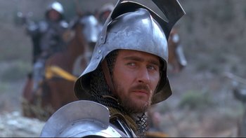 Movie still from “Army of Darkness” (1992), directed by Sam Raimi – A person wearing a helmet; Close Up shot, Low angle