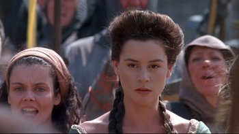 Movie still from “Army of Darkness” (1992), directed by Sam Raimi – A young woman with long hair and a braid; Close Up shot, Over the shoulder angle