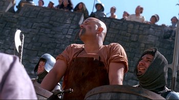 Movie still from “Army of Darkness” (1992), directed by Sam Raimi – A man in an apron is looking up at a crowd; Medium shot, Low angle