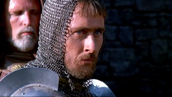 Movie still from “Army of Darkness” (1992), directed by Sam Raimi – A person wearing chain mail; Close Up shot, Low angle