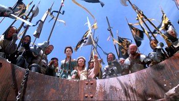 Movie still from “Army of Darkness” (1992), directed by Sam Raimi – A group of people standing on top of a boat; Wide shot, Overhead angle