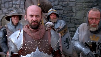 Movie still from “Army of Darkness” (1992), directed by Sam Raimi – Two men dressed in medieval armor and helmets; Medium shot, Low angle