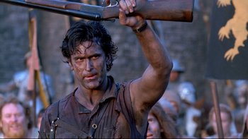 Movie still from “Army of Darkness” (1992), directed by Sam Raimi – A person holding a gun over their head; Medium shot, Low angle