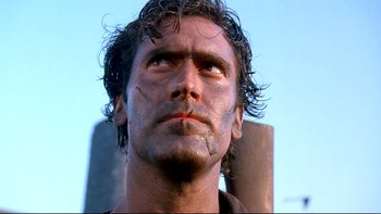 Movie still from “Army of Darkness” (1992), directed by Sam Raimi – A person with a face covered in dirt; Close Up shot, Low angle