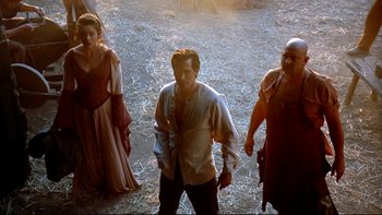 Movie still from “Army of Darkness” (1992), directed by Sam Raimi – A man and two women are standing in a field; Medium shot, Low angle