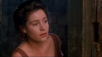 Movie still from “Army of Darkness” (1992), directed by Sam Raimi – A woman in a brown dress looking to her left; Close Up shot, Over the shoulder angle