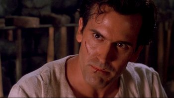 Movie still from “Army of Darkness” (1992), directed by Sam Raimi – A person wearing a shirt and staring at the camera; Close Up shot, Low angle