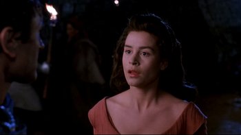 Movie still from “Army of Darkness” (1992), directed by Sam Raimi – A woman in a red dress looking at the camera; Close Up shot, Over the shoulder angle