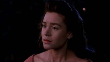 Movie still from “Army of Darkness” (1992), directed by Sam Raimi – A young woman looking into the distance in the dark; Close Up shot, High angle