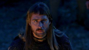 Movie still from “Army of Darkness” (1992), directed by Sam Raimi – A person with long hair and a beard; Close Up shot, Low angle