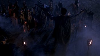 Movie still from “Army of Darkness” (1992), directed by Sam Raimi – A group of people standing in the middle of a field; Extreme Wide shot, High angle