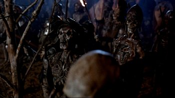 Movie still from “Army of Darkness” (1992), directed by Sam Raimi – A group of people in costumes are gathered together; Medium shot, Over the shoulder angle