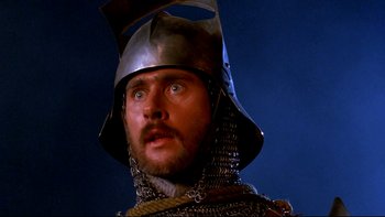 Movie still from “Army of Darkness” (1992), directed by Sam Raimi – A person wearing a helmet; Close Up shot, Low angle