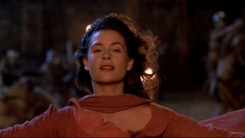 Movie still from “Army of Darkness” (1992), directed by Sam Raimi – A woman with a red scarf is standing in the dark; Close Up shot, Low angle