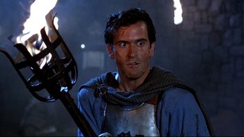 Movie still from “Army of Darkness” (1992), directed by Sam Raimi – A person holding a sword; Close Up shot, Low angle