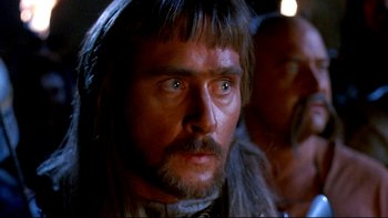Movie still from “Army of Darkness” (1992), directed by Sam Raimi – A person with a beard; Close Up shot, Over the shoulder angle