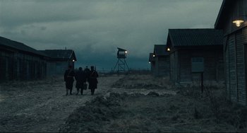 Movie still from “Army of Shadows” (1969), directed by Jean-Pierre Melville – A group of people standing on top of a dirt field; Extreme Wide shot, Low angle
