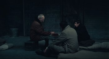 Movie still from “Army of Shadows” (1969), directed by Jean-Pierre Melville – A group of men sitting around a table; Medium shot, High angle