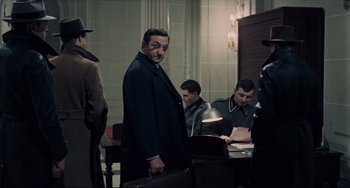 Movie still from “Army of Shadows” (1969), directed by Jean-Pierre Melville – A group of men sitting around a table; Medium shot, Over the shoulder angle