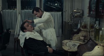 Movie still from “Army of Shadows” (1969), directed by Jean-Pierre Melville – A man getting his hair cut by a barber; Medium shot, Over the shoulder angle