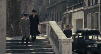 Movie still from “Army of Shadows” (1969), directed by Jean-Pierre Melville – A group of men walking down a set of stairs; Wide shot, High angle