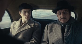 Movie still from “Army of Shadows” (1969), directed by Jean-Pierre Melville – A man and a man in a car; Medium shot, Over the shoulder angle