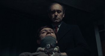 Movie still from “Army of Shadows” (1969), directed by Jean-Pierre Melville – A man with a bandage around his face and a man with a tie around his neck; Close Up shot, Low angle