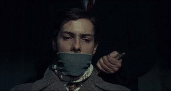 Movie still from “Army of Shadows” (1969), directed by Jean-Pierre Melville – A man with a tie around his face and a cigarette in his mouth; Close Up shot, Low angle
