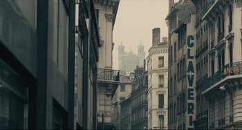 Movie still from “Army of Shadows” (1969), directed by Jean-Pierre Melville – A view of a very tall building from a very narrow street; Extreme Wide shot, Low angle