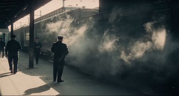 Movie still from “Army of Shadows” (1969), directed by Jean-Pierre Melville – A man standing in front of a train; Wide shot, High angle