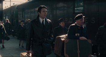 Movie still from “Army of Shadows” (1969), directed by Jean-Pierre Melville – A group of men standing next to each other near a train; Medium shot, Over the shoulder angle