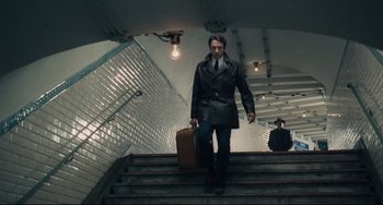 Movie still from “Army of Shadows” (1969), directed by Jean-Pierre Melville – A man with a briefcase walking up some stairs; Wide shot, Low angle