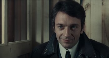 Movie still from “Army of Shadows” (1969), directed by Jean-Pierre Melville – A person wearing a suit and tie; Close Up shot, Over the shoulder angle