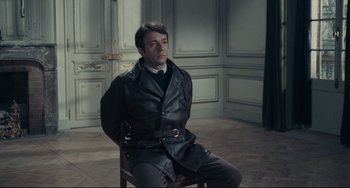 Movie still from “Army of Shadows” (1969), directed by Jean-Pierre Melville – A man sitting on a chair in a room; Medium shot, High angle