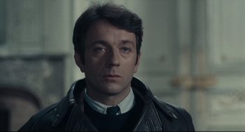 Movie still from “Army of Shadows” (1969), directed by Jean-Pierre Melville – A person wearing a jacket and tie; Close Up shot, Over the shoulder angle