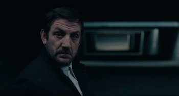 Movie still from “Army of Shadows” (1969), directed by Jean-Pierre Melville – A person wearing a suit and tie; Close Up shot, Low angle