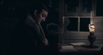 Movie still from “Army of Shadows” (1969), directed by Jean-Pierre Melville – A man sitting at a table writing on a piece of paper; Medium shot, High angle