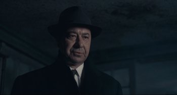 Movie still from “Army of Shadows” (1969), directed by Jean-Pierre Melville – An older man wearing a hat and a suit; Close Up shot, Low angle