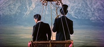 Movie still from “Around the World in 80 Days” (1956), directed by John Farrow – Two men in suits are in a hot air balloon; Wide shot, Low angle