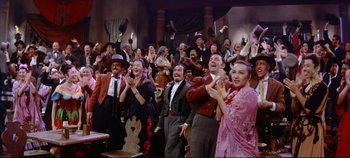 Movie still from “Around the World in 80 Days” (1956), directed by John Farrow – A group of people are clapping in front of a crowd; Wide shot, Low angle